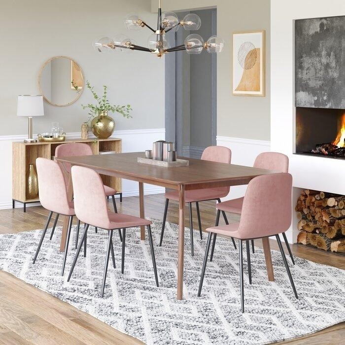 современная столовая с деревянным столом и мягкими розовыми обеденными стульями на металлических тонких ножках.jpeg