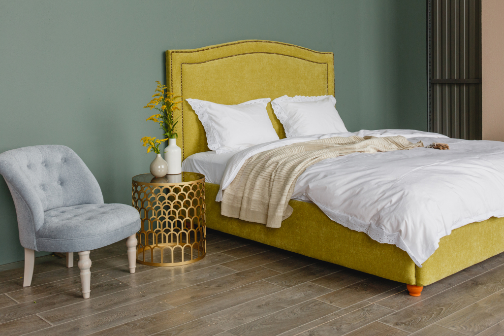 мягкая кровать ярко-желтого цвета, золотой прикроватный столик и светло-голубое кресло.jpg